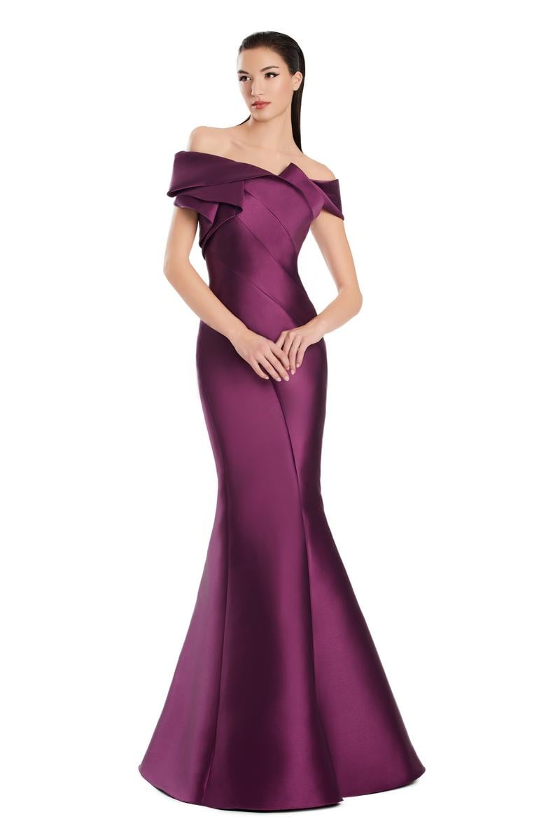 Model wearing Alexander By Daymor 3079CS25 evening gown featuring an off-the-shoulder pleated neckline and flared hemline.
