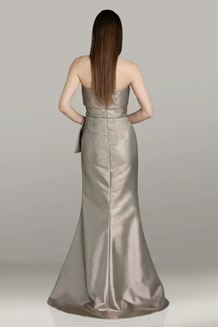 Model wearing Gia Franco 12562 strapless mermaid gown with side bow detail and fitted silhouette.