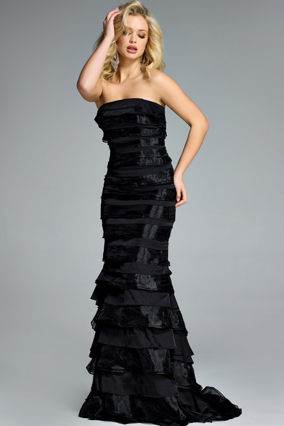 Model wearing Jovani 44383 strapless tiered ruffle gown with fitted silhouette and sweep train.