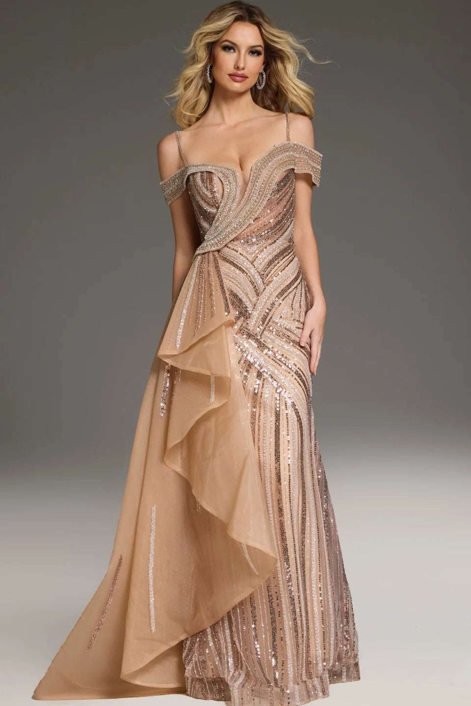 Jovani 44843 Beaded Off-Shoulder Gown featuring intricate beadwork, an off-shoulder neckline, and a layered asymmetrical overskirt. Model is wearing the dress in the color champagne.