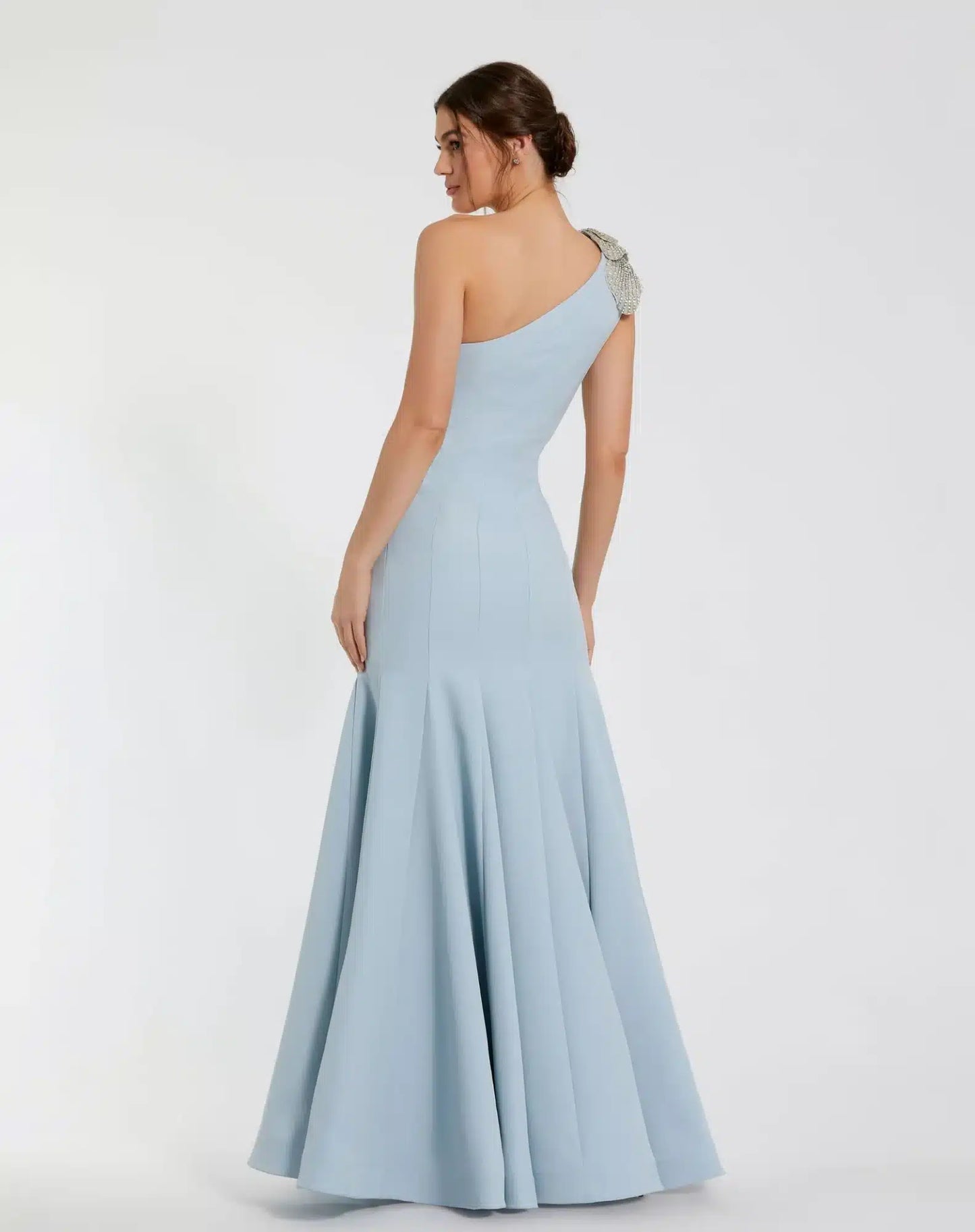 Model wearing Mac Duggal 11810 one-shoulder trumpet gown with flower detail. Model wearing the dress in the color powder blue. Back view.
