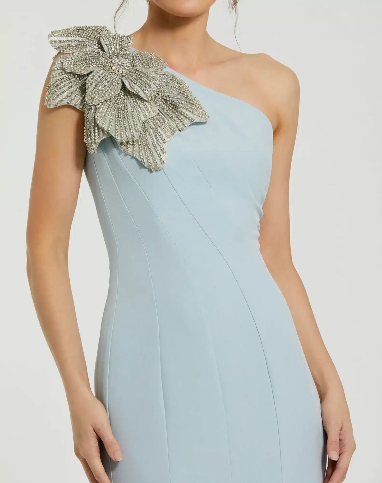 Model wearing Mac Duggal 11810 one-shoulder trumpet gown with flower detail. Model wearing the dress in the color powder blue. Close Up.