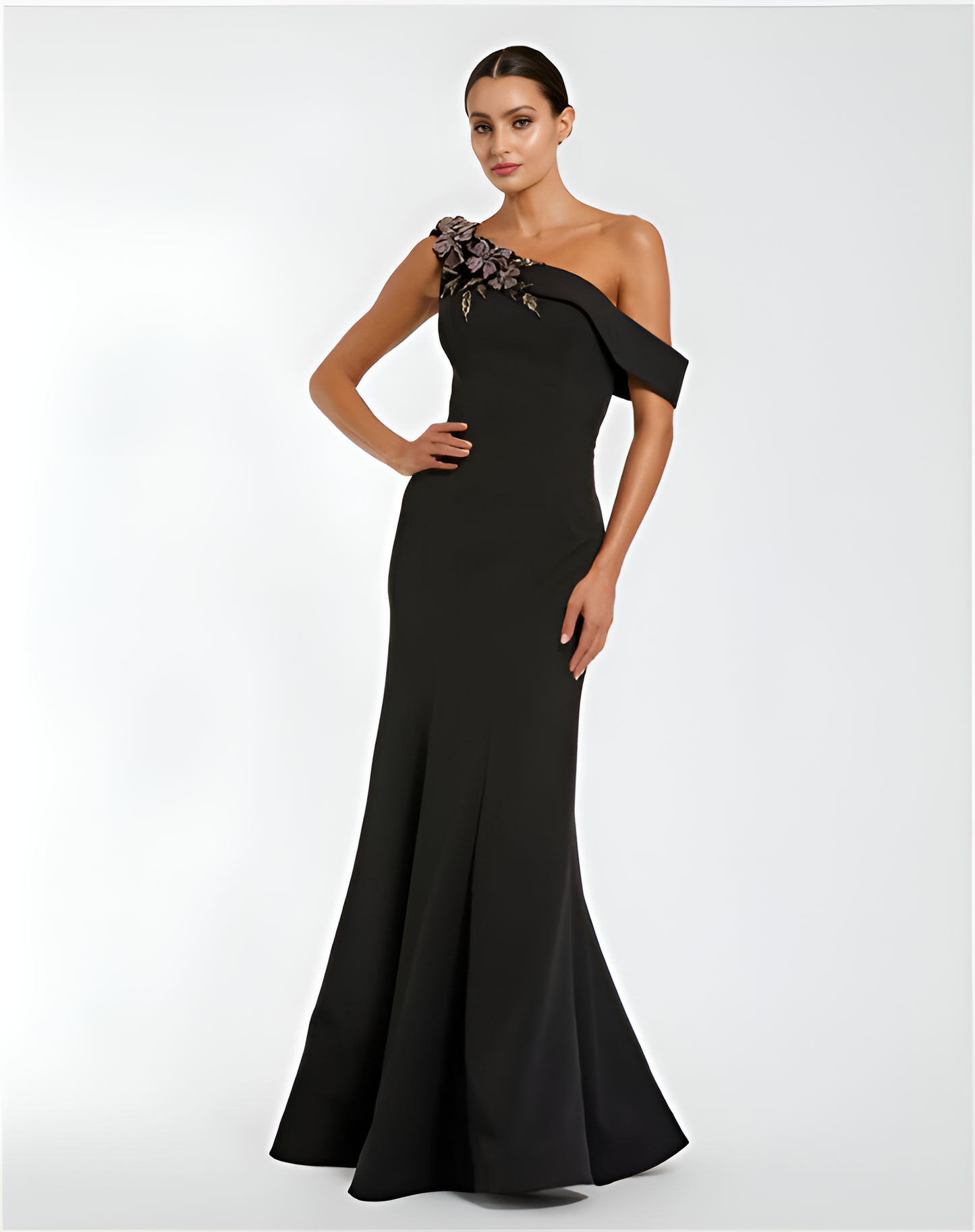 Black one-shoulder evening gown with floral detail on a white background