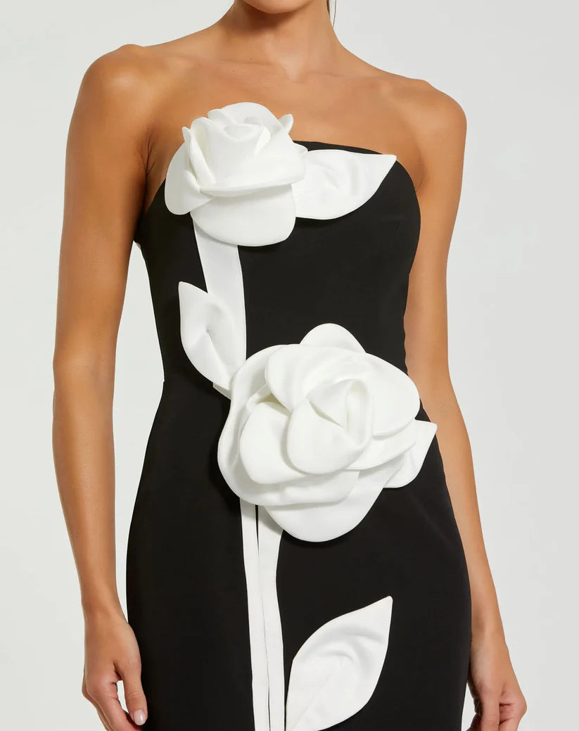 Model wearing Mac Duggal 2283 strapless crepe gown with 3D satin floral appliqués and back slit. Close up of the dress.