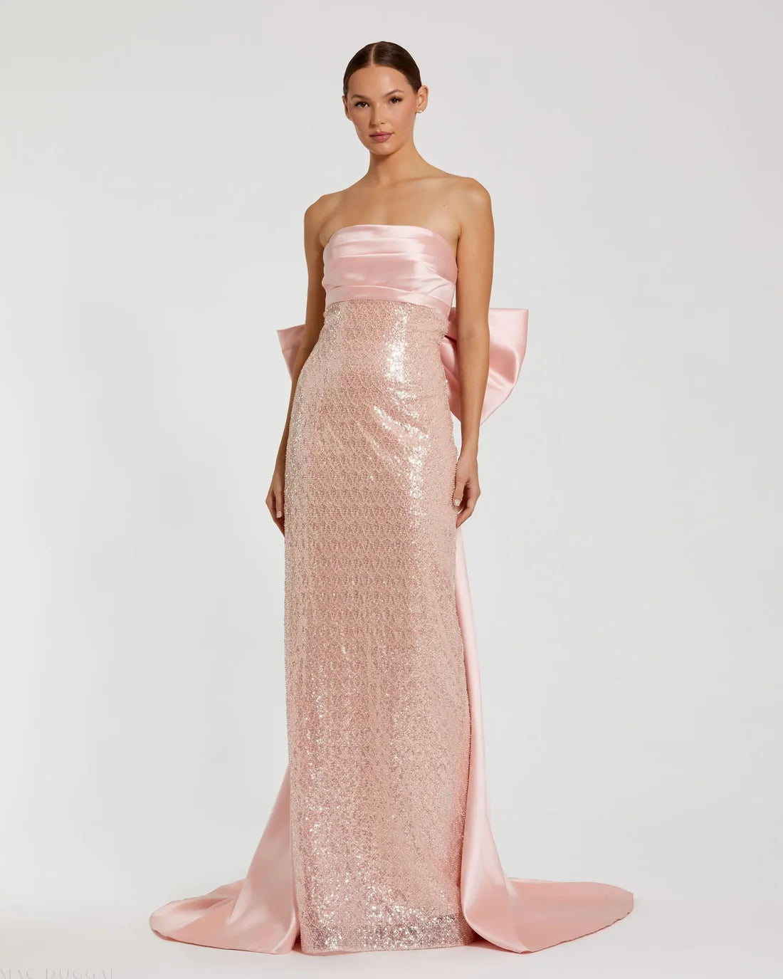 Model wearing Mac Duggal 37011 strapless gown featuring a sleek silhouette with an oversized bow detail on the back. Front view. Model wearing the color blush.