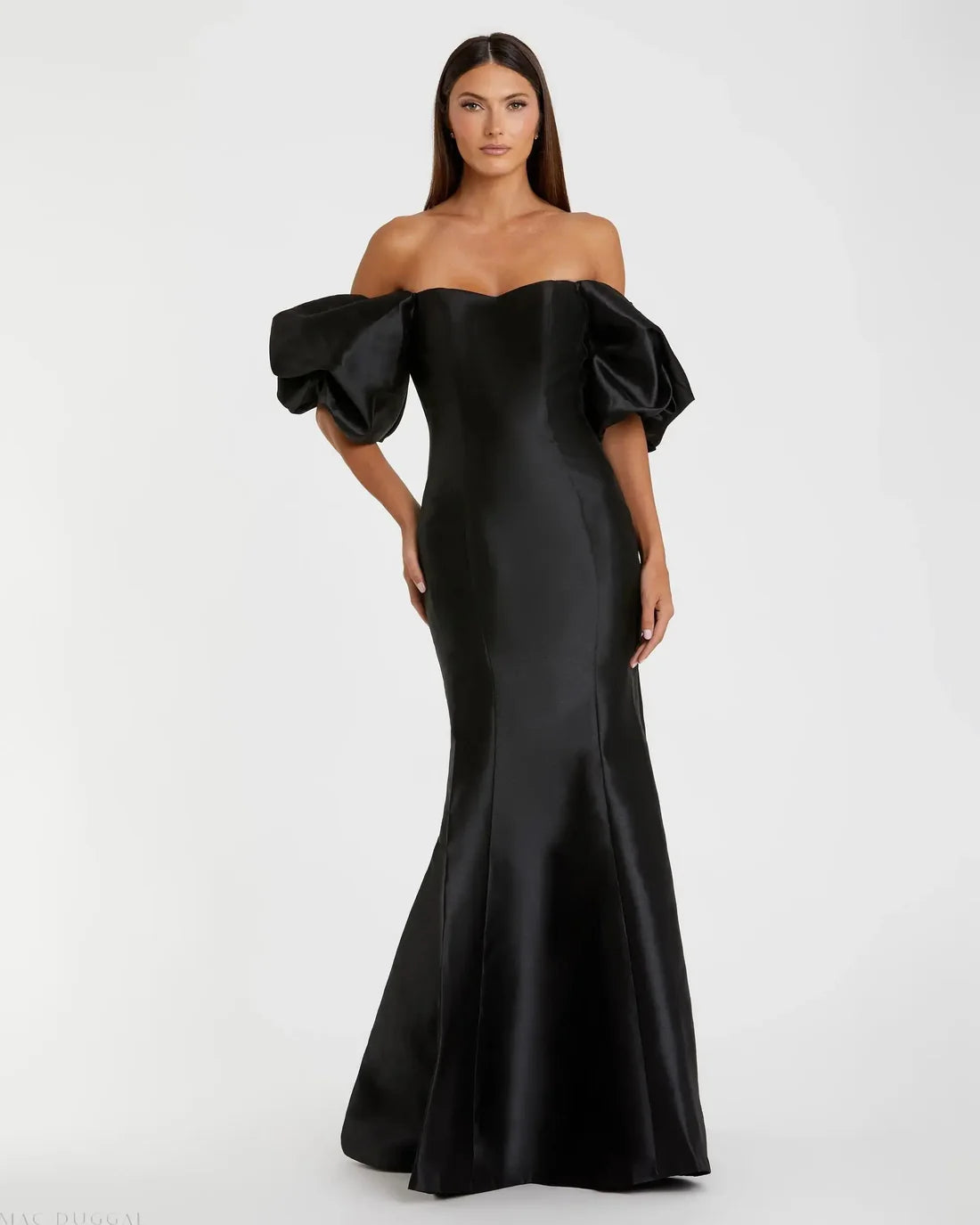 Model wearing Mac Duggal 50677 off-the-shoulder satin gown with puff sleeves, mermaid silhouette, and sweeping train. Model is wearing the color black. Front view.