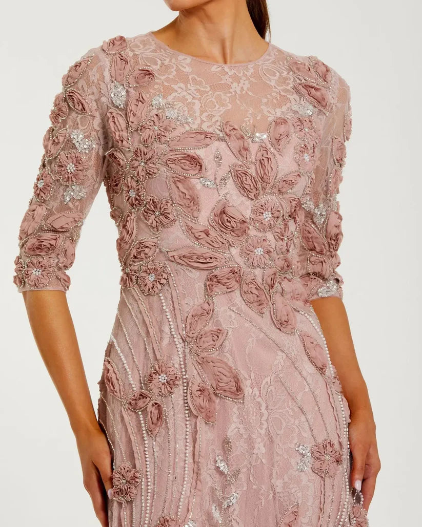 Model wearing Mac Duggal 69016 gown with illusion neckline, 3/4 sheer sleeves, 3D rosettes, and a flowing embellished skirt. Front close up of the dress.