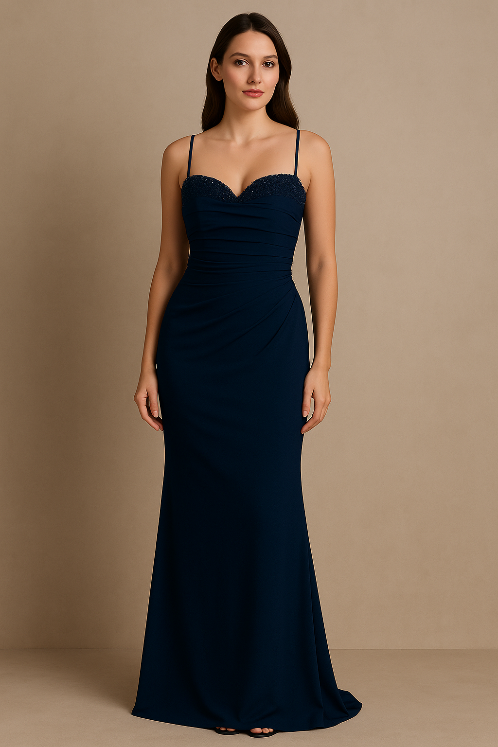 Model wearing the Madeline’s Bella gown with beaded bodice, spaghetti straps, and ruched fitted skirt in navy and emerald green.
