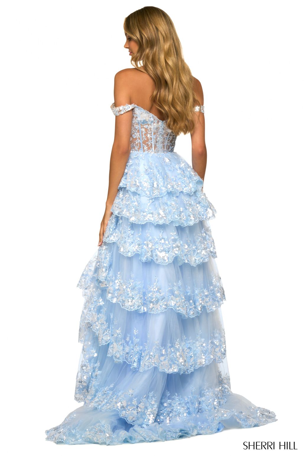 A captivating tulle sequin A-line gown with a sheer corset bodice, off-the-shoulder straps, and a ruffle high slit skirt. Ideal for prom, red carpet events, and pageants.