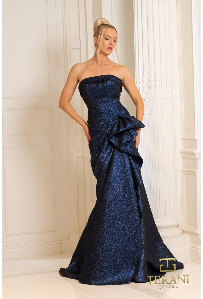 Model wearing Terani 252E5200 strapless metallic jacquard fit and flare gown with side draping detail. Wearing Navy.