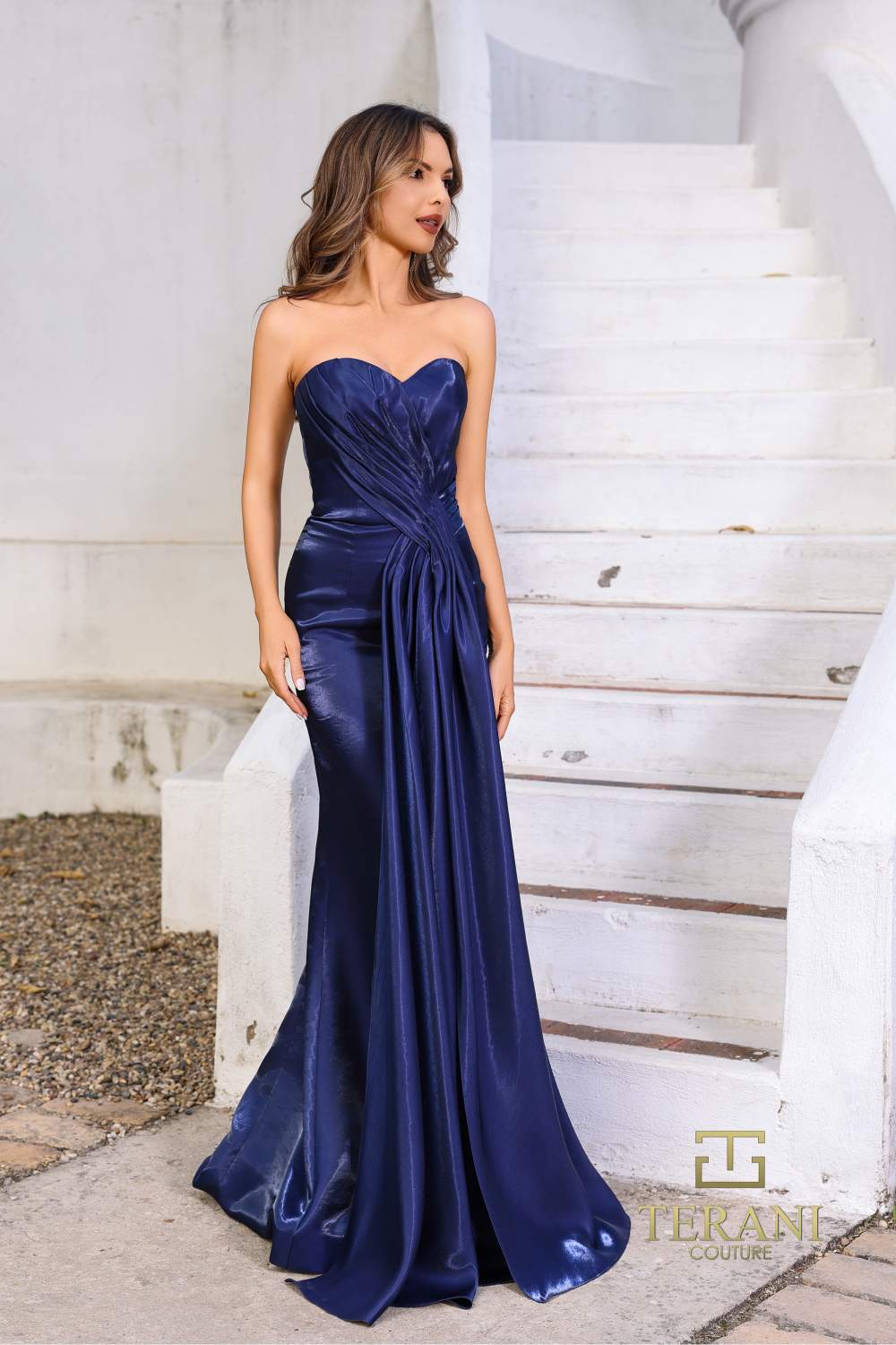 Model wearing Terani 252E5512 strapless shimmer organza gown with pleated bodice and fit and flare silhouette.