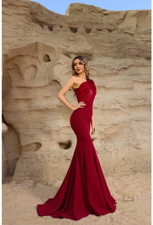 Model wearing Terani Couture 252E5514 one-shoulder gown with puff sleeve, draped bodice, and chapel train in the color wine.