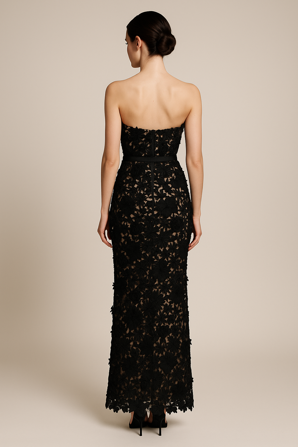 Model wearing Madeline’s Amiri strapless gown featuring 3D floral detailing, fitted silhouette, and slim belt in the color black/nude.