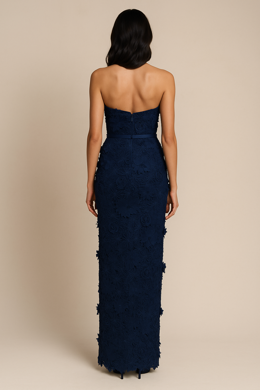 Model wearing Madeline’s Amiri strapless gown featuring 3D floral detailing, fitted silhouette, and slim belt in the color navy/navy.  Back View.