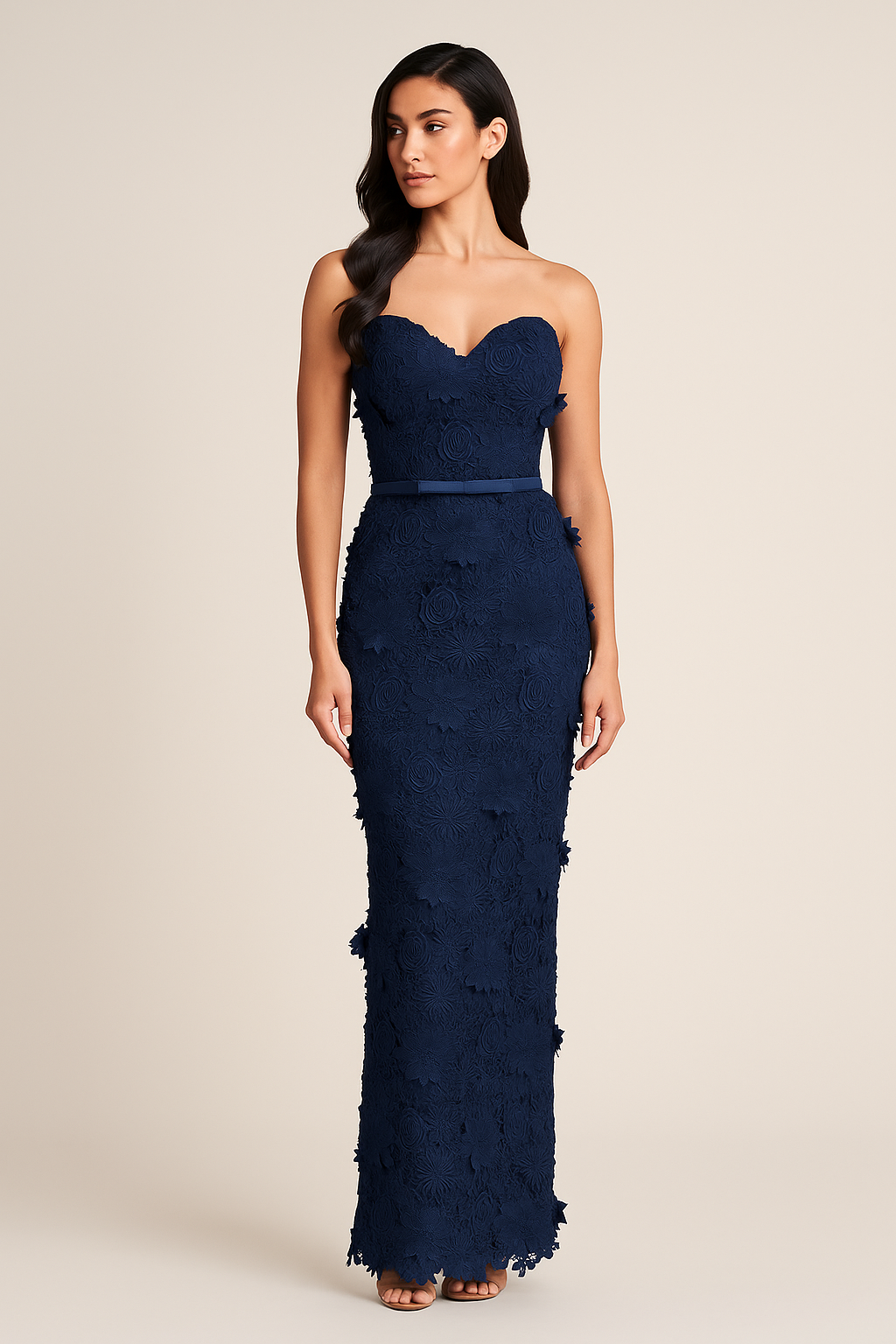 Model wearing Madeline’s Amiri strapless gown featuring 3D floral detailing, fitted silhouette, and slim belt in the color navy/navy.