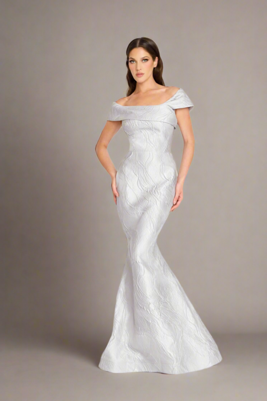 Nicole Bakti 7299 Off-Shoulder Metallic Jacquard Gown – Elegant off-shoulder gown with fitted silhouette and flared hem in luxurious metallic jacquard fabric.