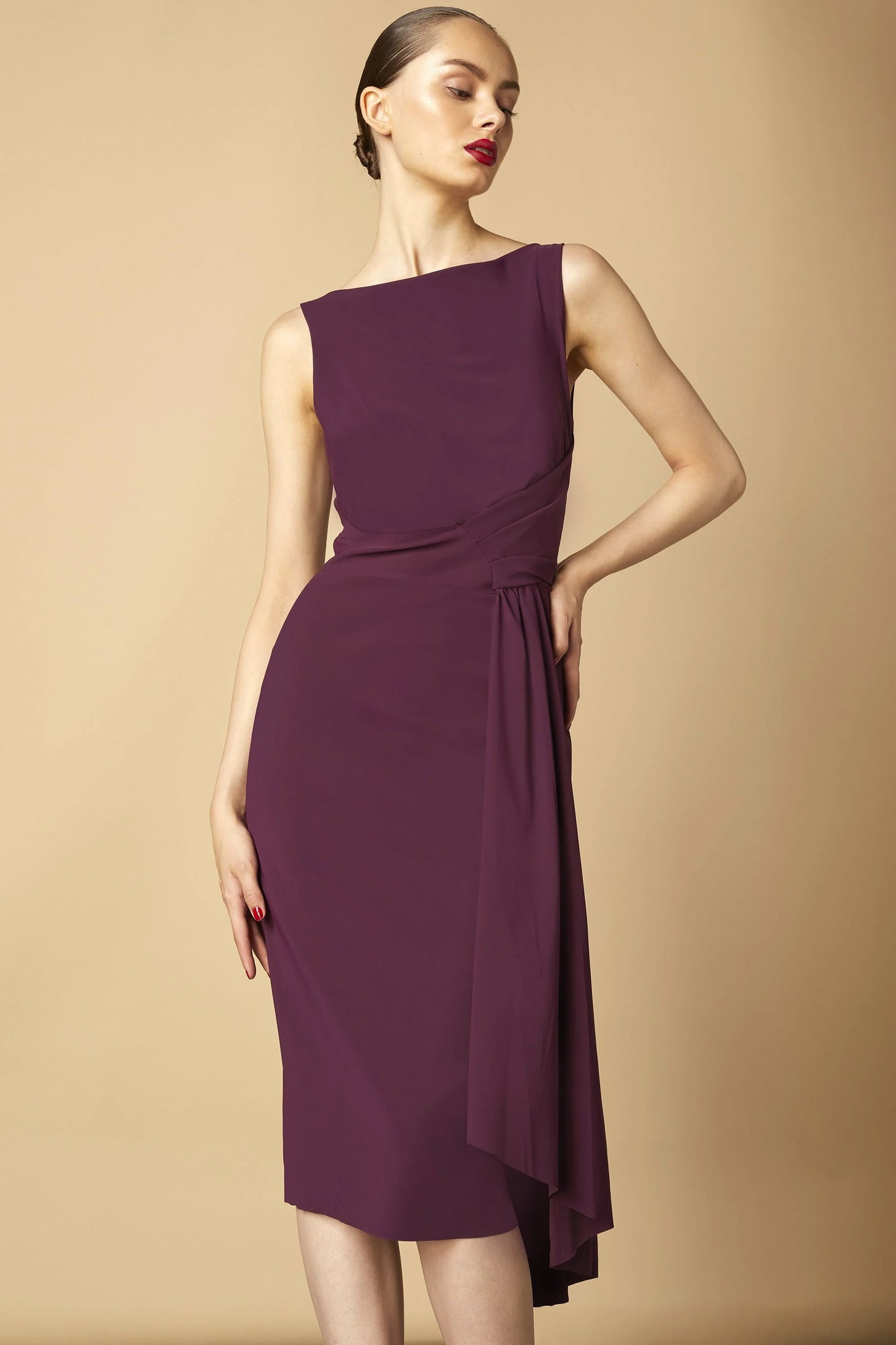 Model wearing Chiara Boni Cinthia draped asymmetric midi dress with bateau neckline and gathered waist detail.