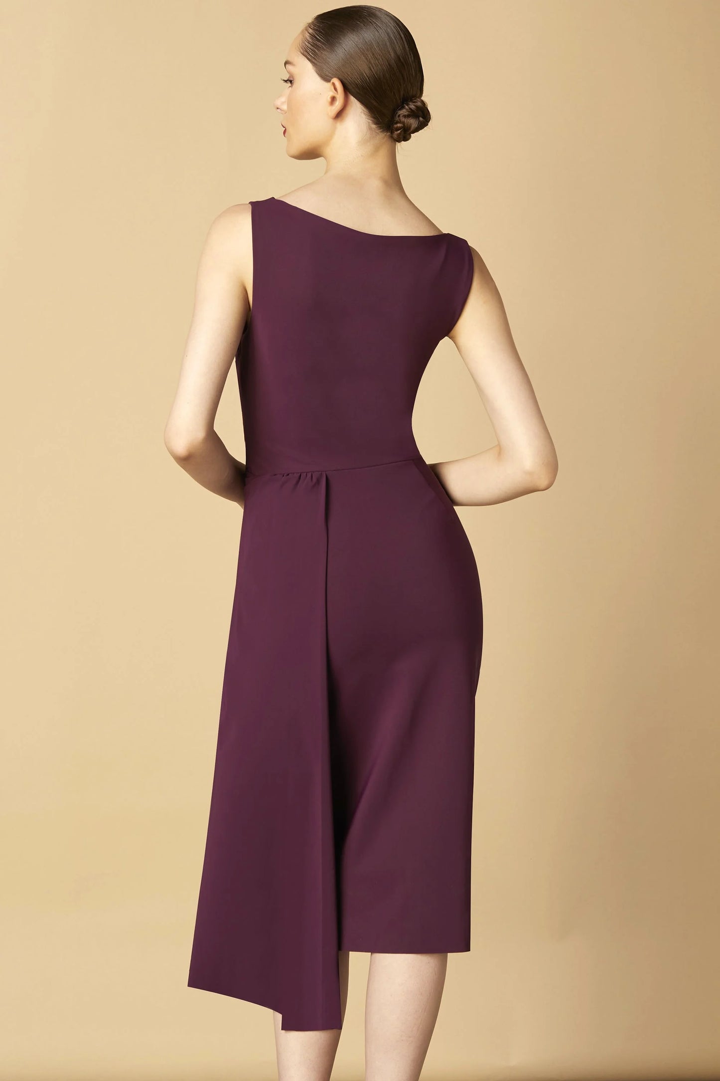 Model wearing Chiara Boni Cinthia draped asymmetric midi dress with bateau neckline and gathered waist detail.