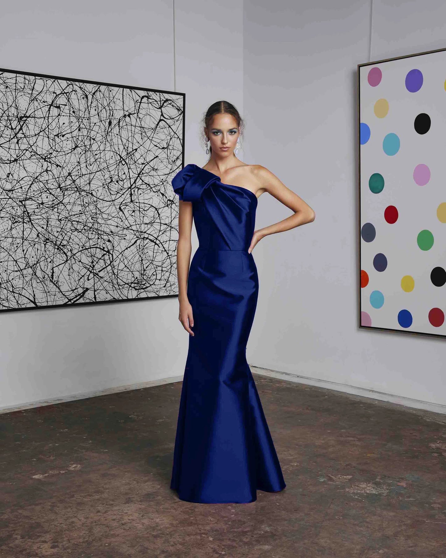 Frascara 4612 - A chic one-shoulder evening gown with an asymmetrical bow detail, perfect for formal evenings and mother of the bride or groom occasions. The model is wearing the dress in indigo.