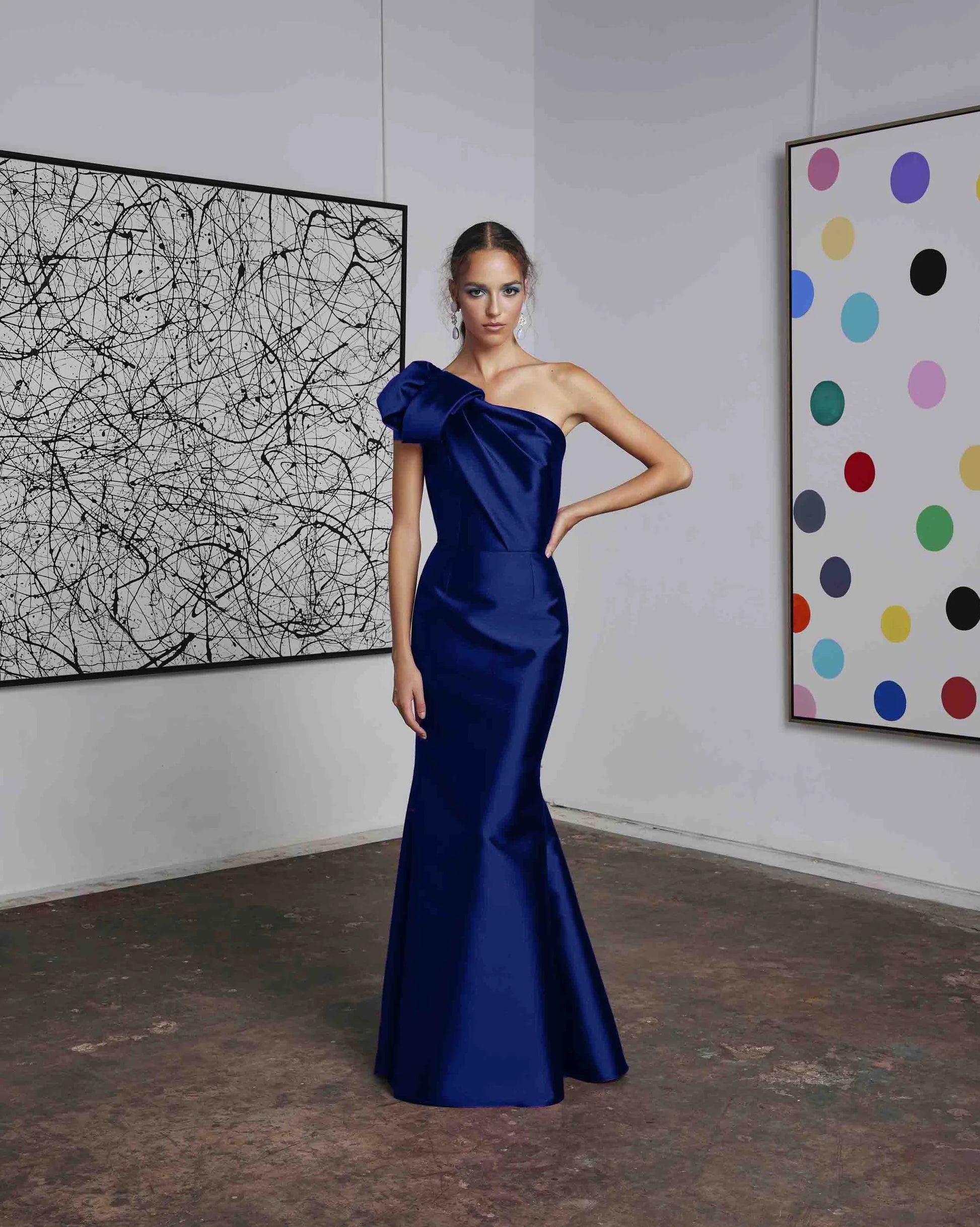 Frascara 4612 - A chic one-shoulder evening gown with an asymmetrical bow detail, perfect for formal evenings and mother of the bride or groom occasions. The model is wearing the dress in indigo.