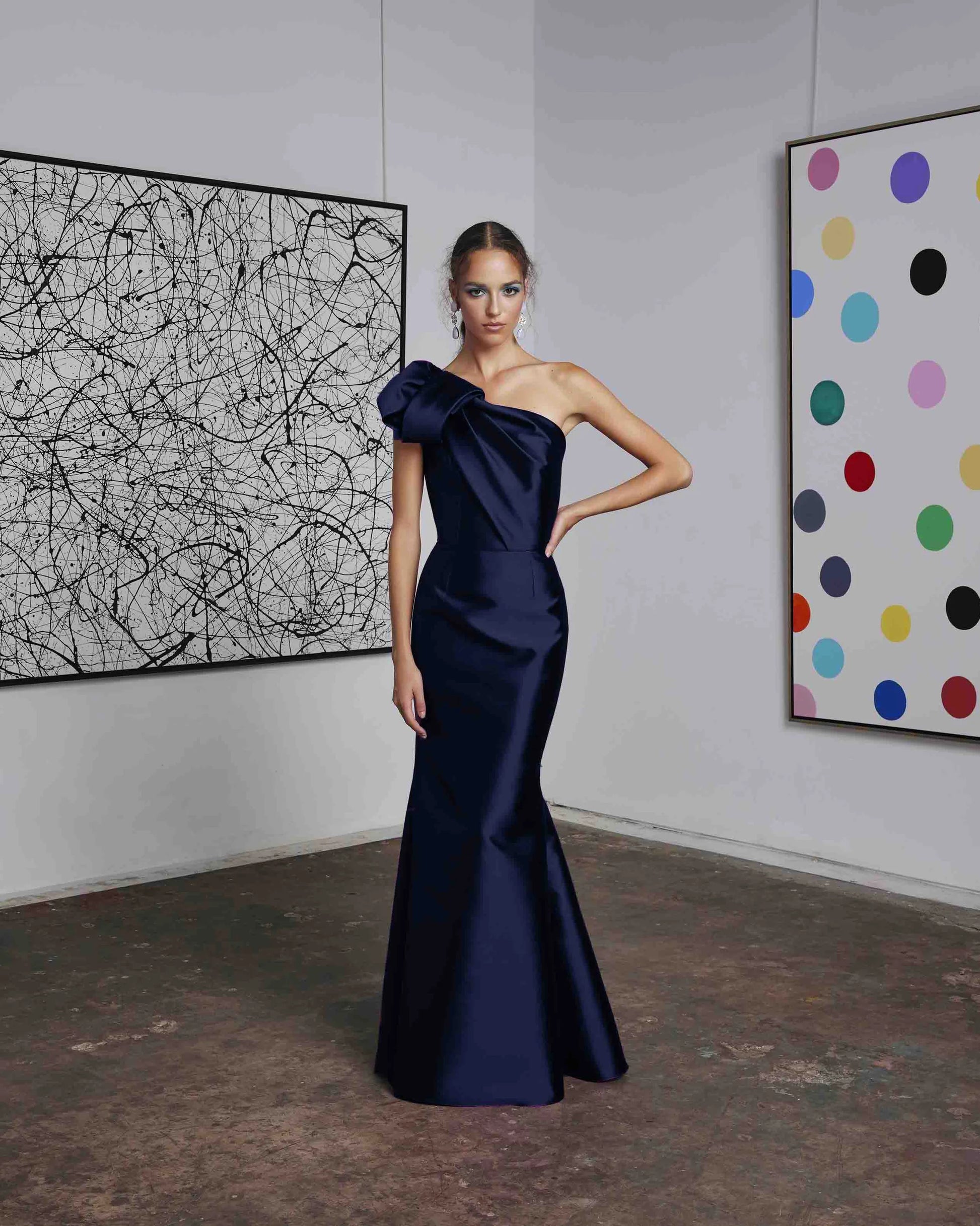 Frascara 4612 - A chic one-shoulder evening gown with an asymmetrical bow detail, perfect for formal evenings and mother of the bride or groom occasions. The model is wearing the dress in navy.