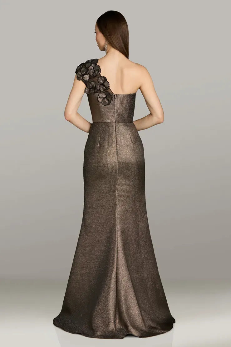 Model wearing Gia Franco 12550 one-shoulder gown with floral appliqué detail and subtle flared hem.