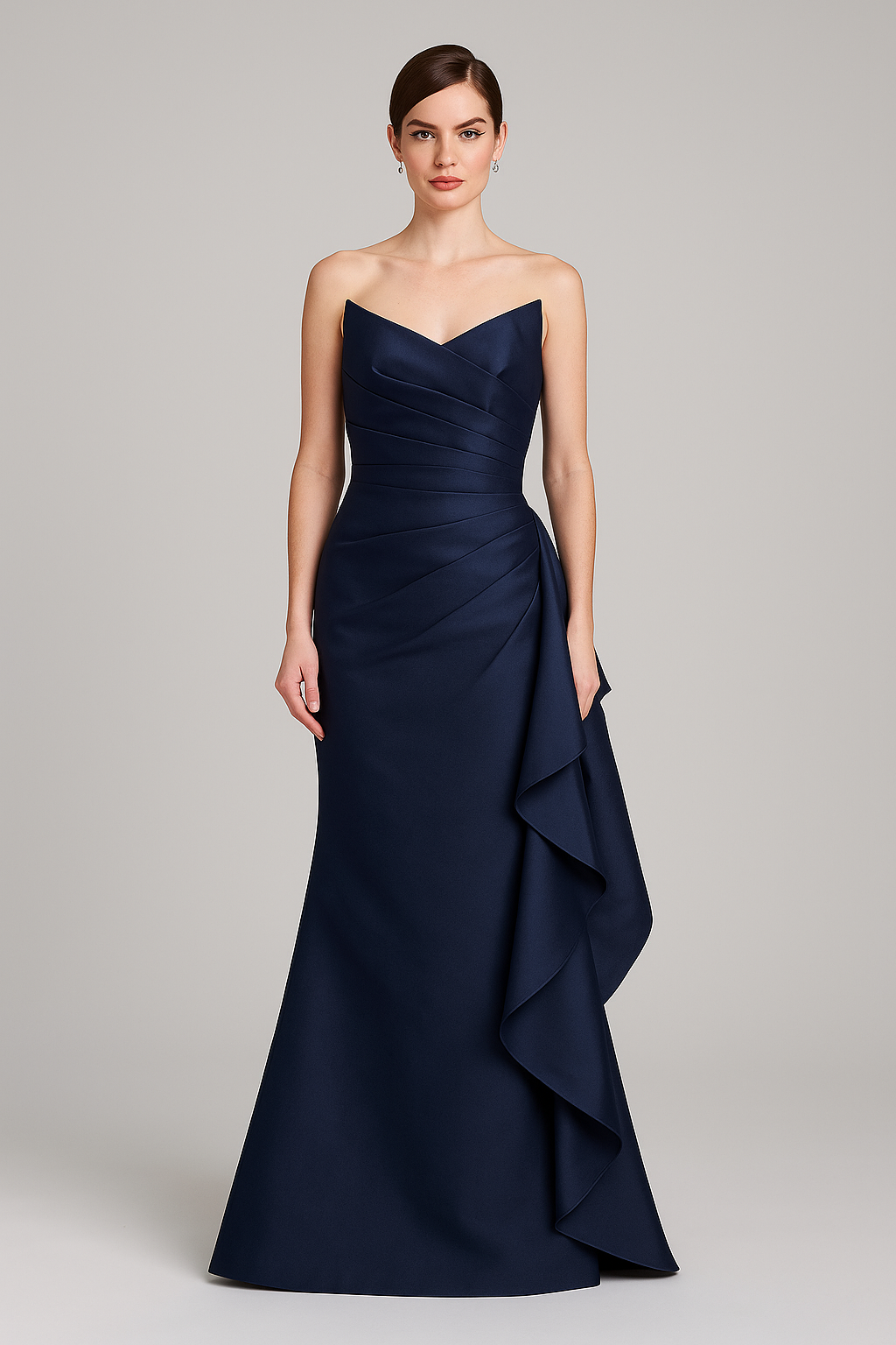 Navy blue strapless gown with a ruffled skirt on a gray background