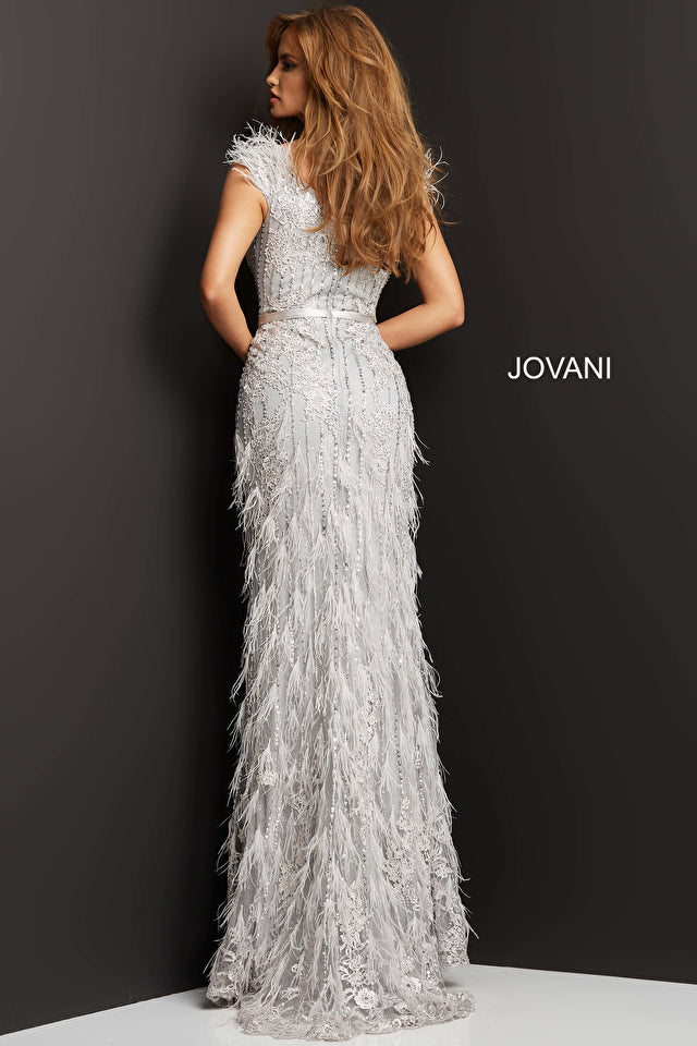 A woman wearing a stunning beaded and lace embroidered evening gown with feather embellished floor-length skirt, perfect for black tie events and red carpet occasions.