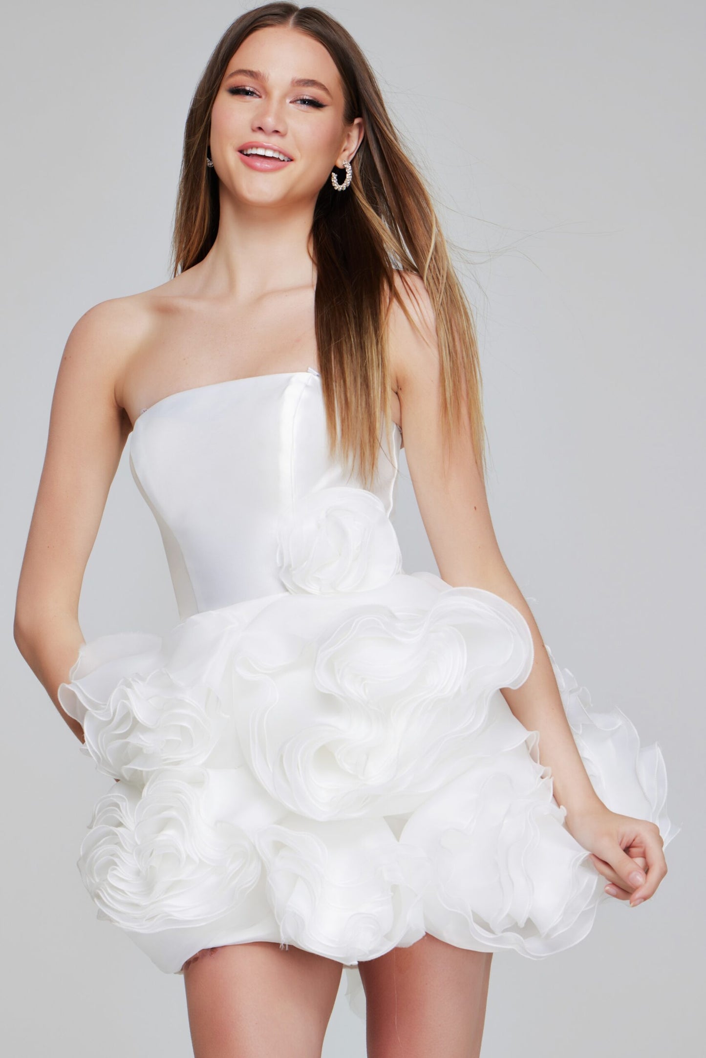 A front view of the Jovani 40334 strapless cocktail dress in white, featuring a structured bodice and a voluminous skirt with organza rosette ruffles.