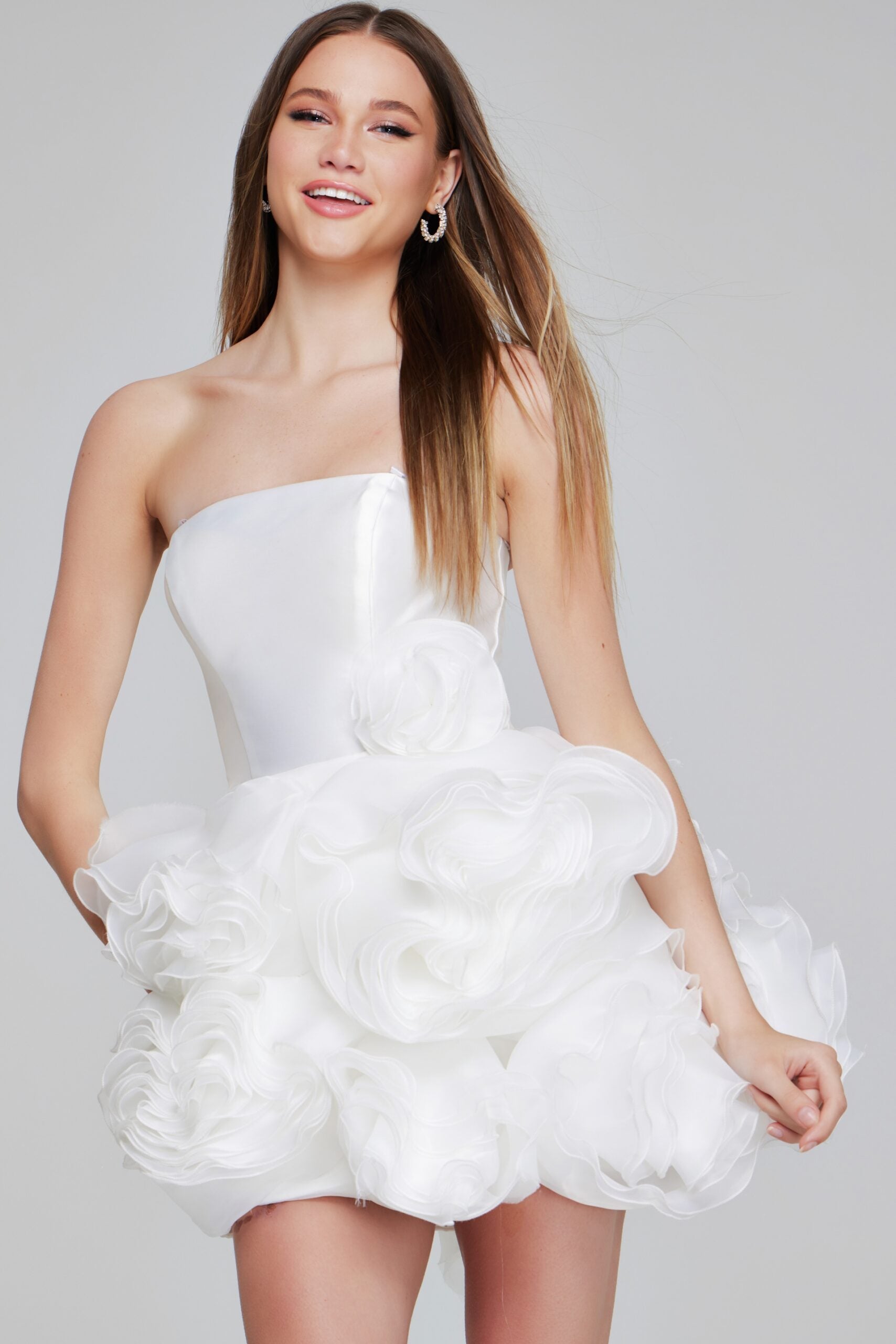 A front view of the Jovani 40334 strapless cocktail dress in white, featuring a structured bodice and a voluminous skirt with organza rosette ruffles.