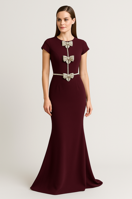 Model wearing Jovani 47619 gown with embellished bows, fitted silhouette, and floor-length design.