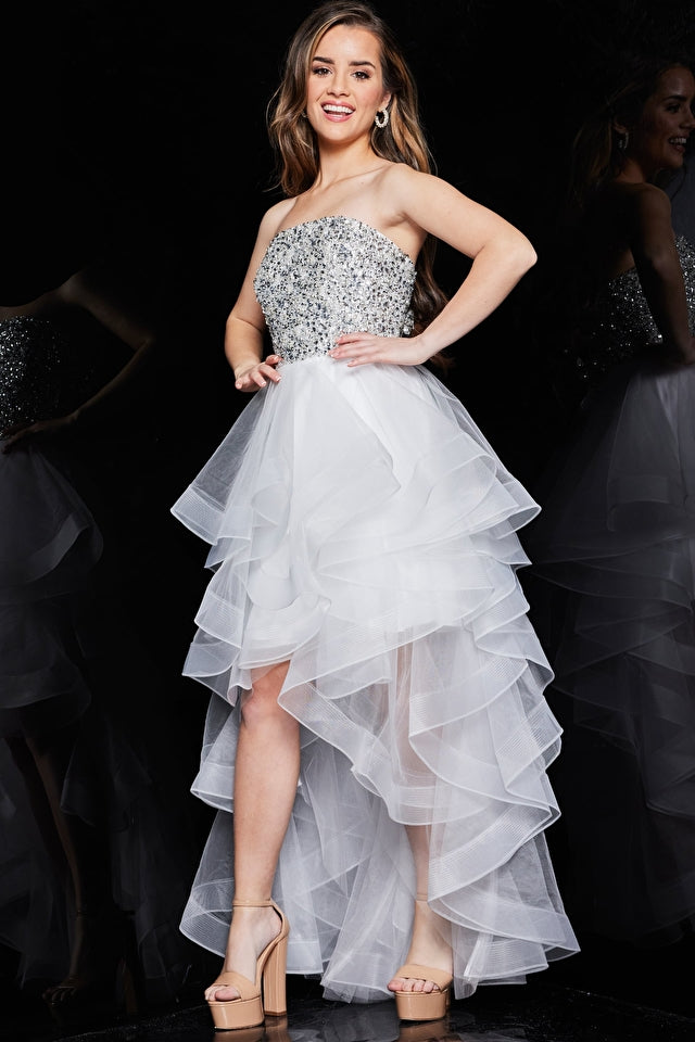 Model wearing Jovani K05916 strapless beaded high-low dress with sparkling bodice and layered ruffle skirt.