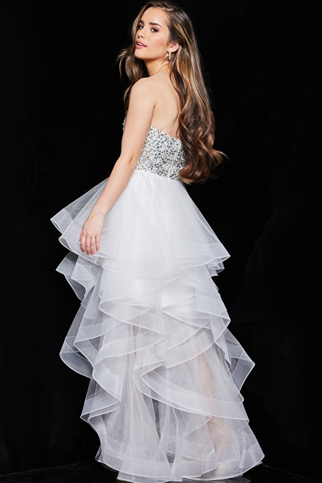 Model wearing Jovani K05916 strapless beaded high-low dress with sparkling bodice and layered ruffle skirt.
