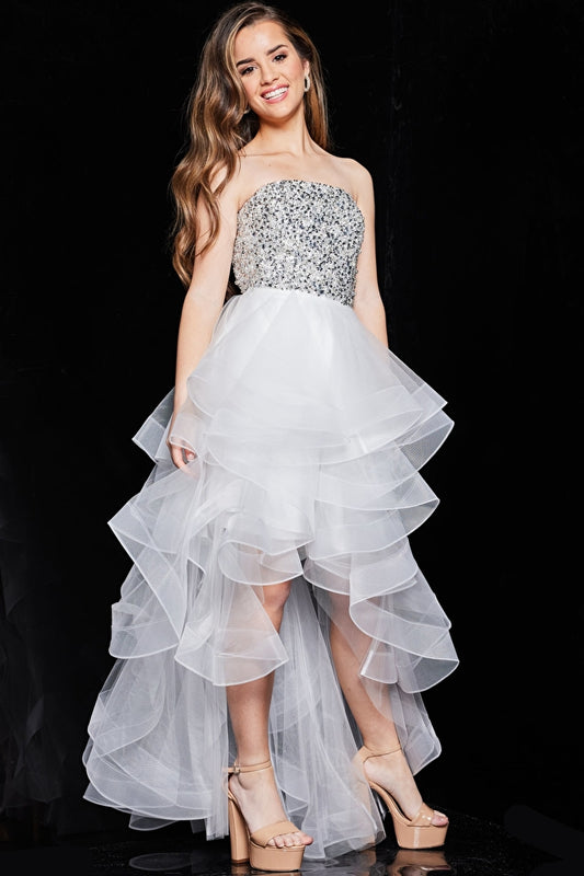 Model wearing Jovani K05916 strapless beaded high-low dress with sparkling bodice and layered ruffle skirt.