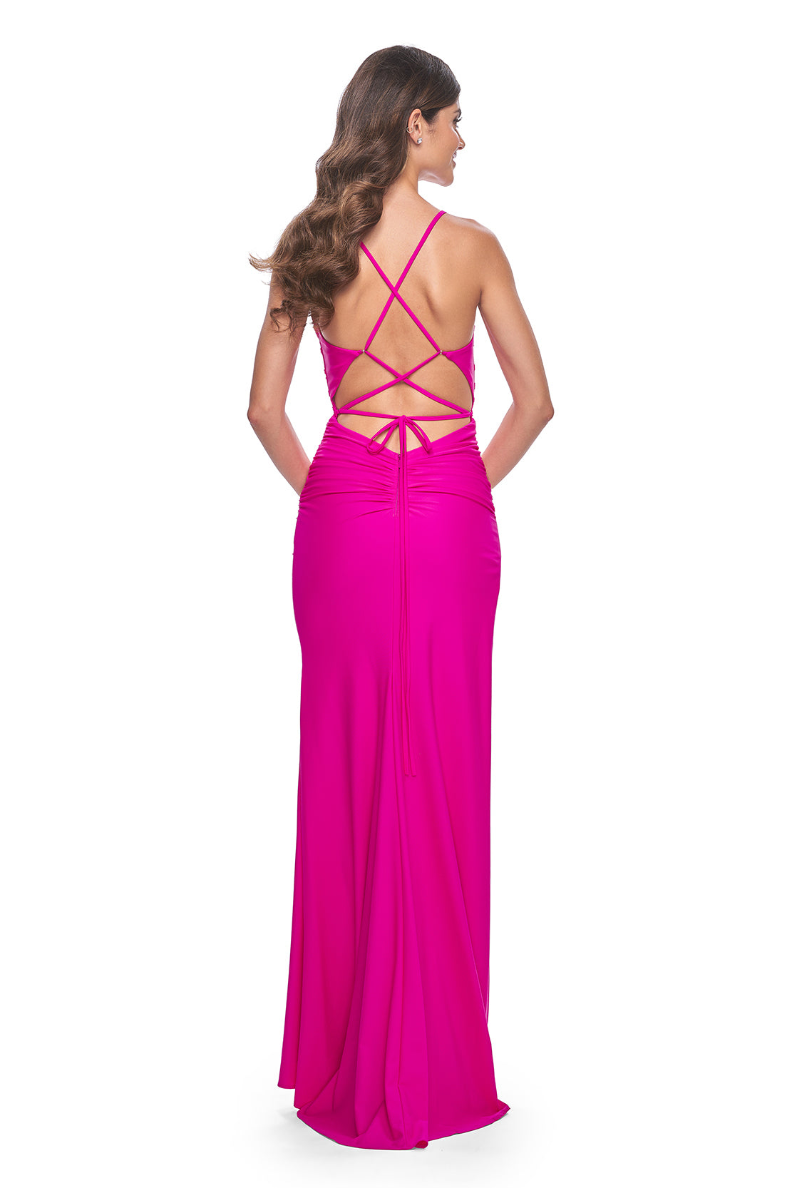 La Femme 32152 Ruched Jersey Prom Dress - Elevate your prom look with this meticulously ruched jersey gown featuring a gracefully draped neckline, an alluring open lace-up back, and a high slit for added glamour. The model is wearing the dress in the color hot fuchsia.