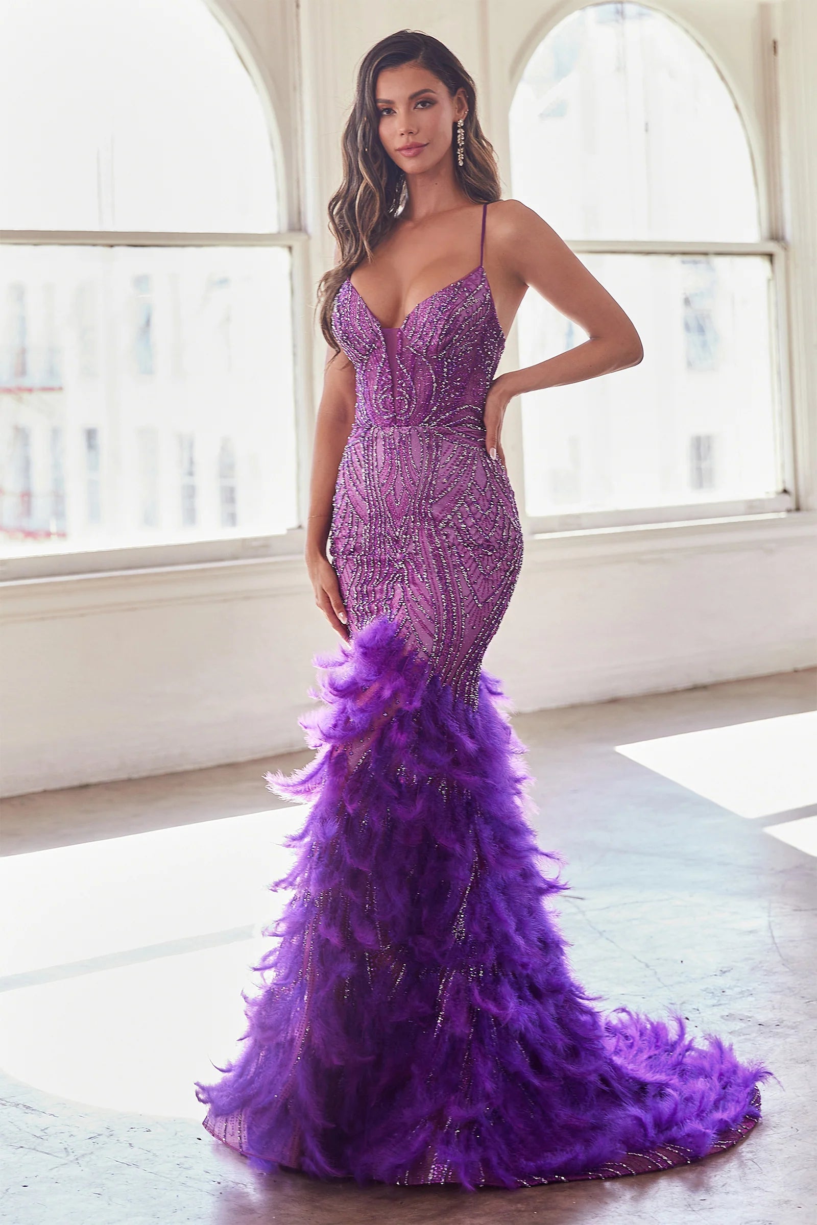 LaDivine CC2308 Enchanting Mermaid Prom Dress - A captivating mermaid silhouette dress with thin straps, v-neckline, glitter and bead embellishments on the sheer boned bodice, a tiered feathered skirt, and an open lace-up corset back. The model is wearing the dress in Nova Purple.