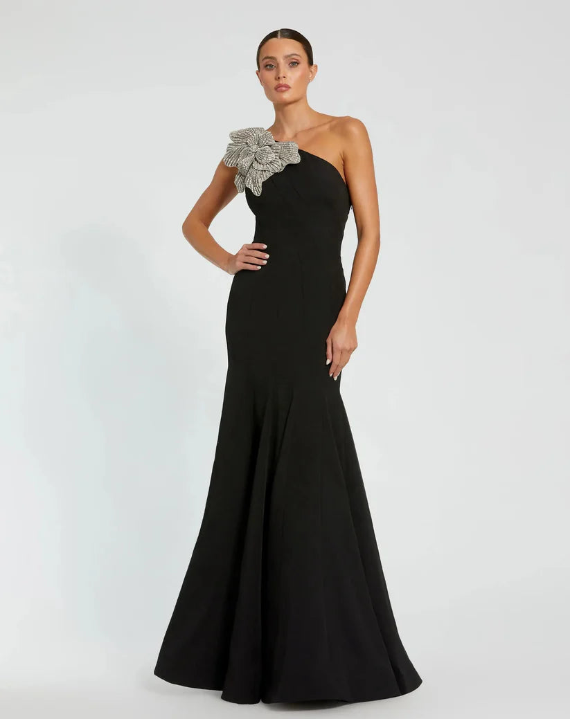Model wearing Mac Duggal 11810 one-shoulder trumpet gown with flower detail.