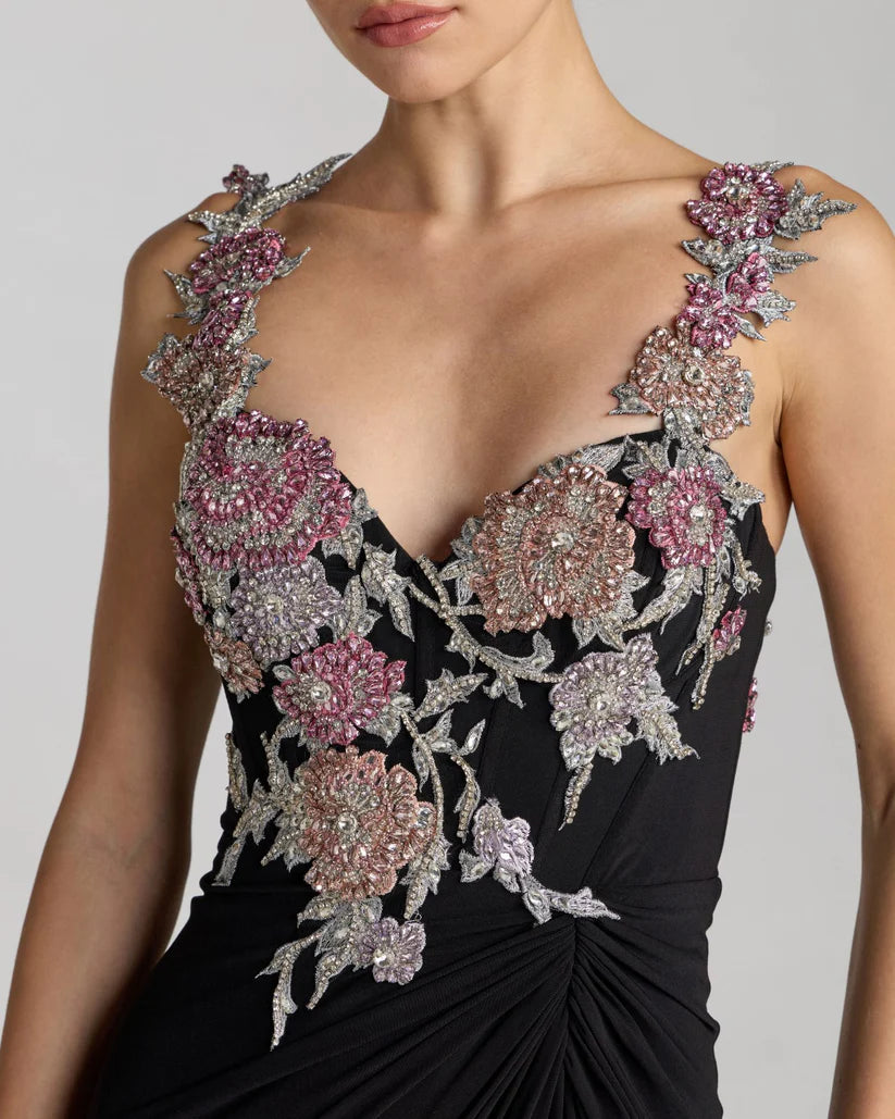 Black evening gown with floral and bead embellishments on a plain background