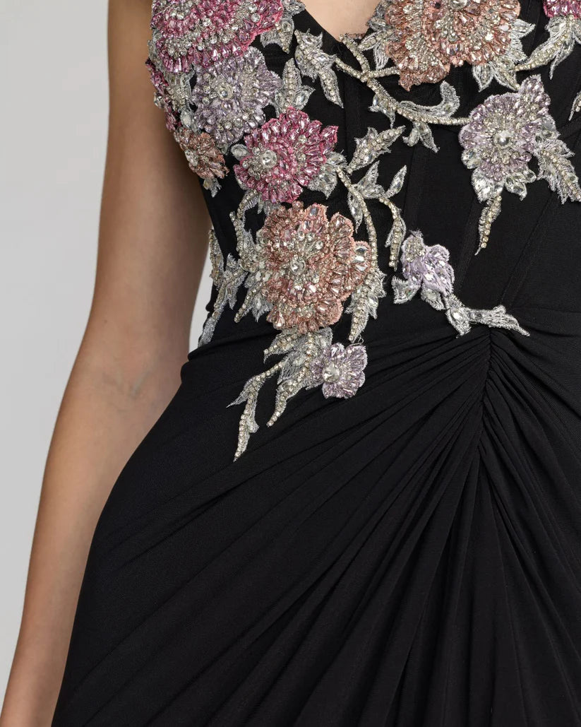 Black evening gown with floral embellishments on a plain background