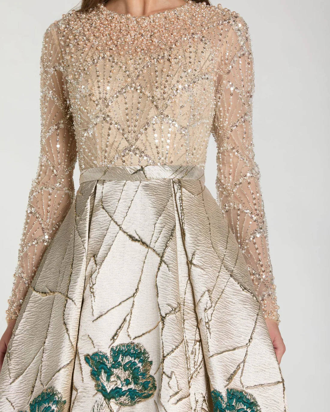 Model wearing Mac Duggal 21182 long-sleeve beaded A-line gown with illusion neckline and brocade skirt.