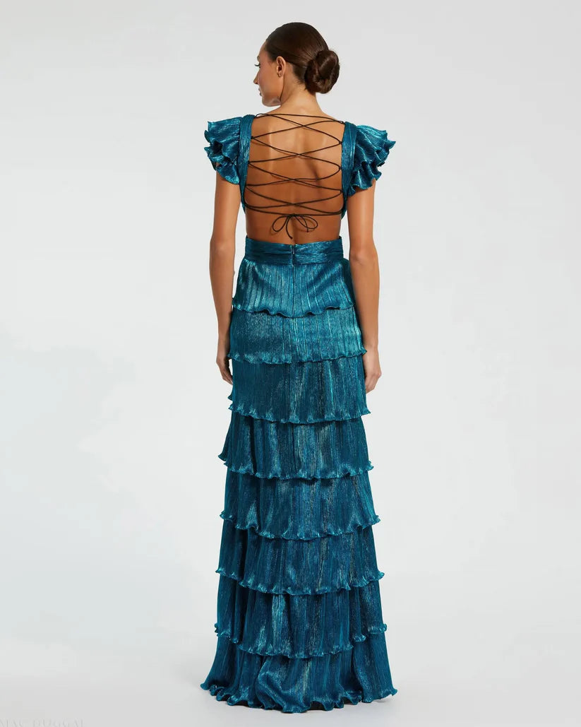 Model wearing Mac Duggal 26740 gown with deep V-neckline, ruffled sleeves, tiered pleated skirt, lace-up back, and thigh-high slit.  Model is wearing the color blue.  Back View.