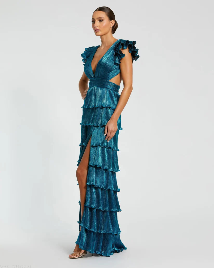 Model wearing Mac Duggal 26740 gown with deep V-neckline, ruffled sleeves, tiered pleated skirt, lace-up back, and thigh-high slit.  Model is wearing the color blue.  3/4 Side view of the dress.