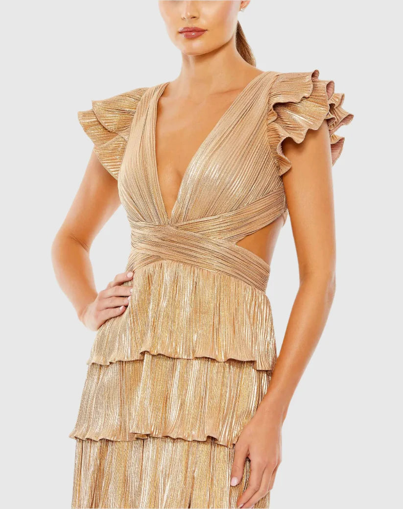 Model wearing Mac Duggal 26740 gown with deep V-neckline, ruffled sleeves, tiered pleated skirt, lace-up back, and thigh-high slit.  Model is wearing the color gold.  Close Up.