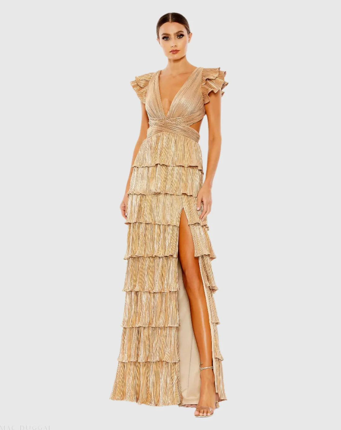 Model wearing Mac Duggal 26740 gown with deep V-neckline, ruffled sleeves, tiered pleated skirt, lace-up back, and thigh-high slit.  Model is wearing the color gold.