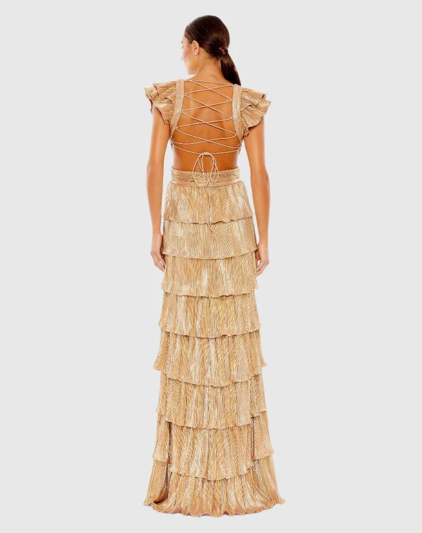 Model wearing Mac Duggal 26740 gown with deep V-neckline, ruffled sleeves, tiered pleated skirt, lace-up back, and thigh-high slit.  Model is wearing the color gold.  Back View.