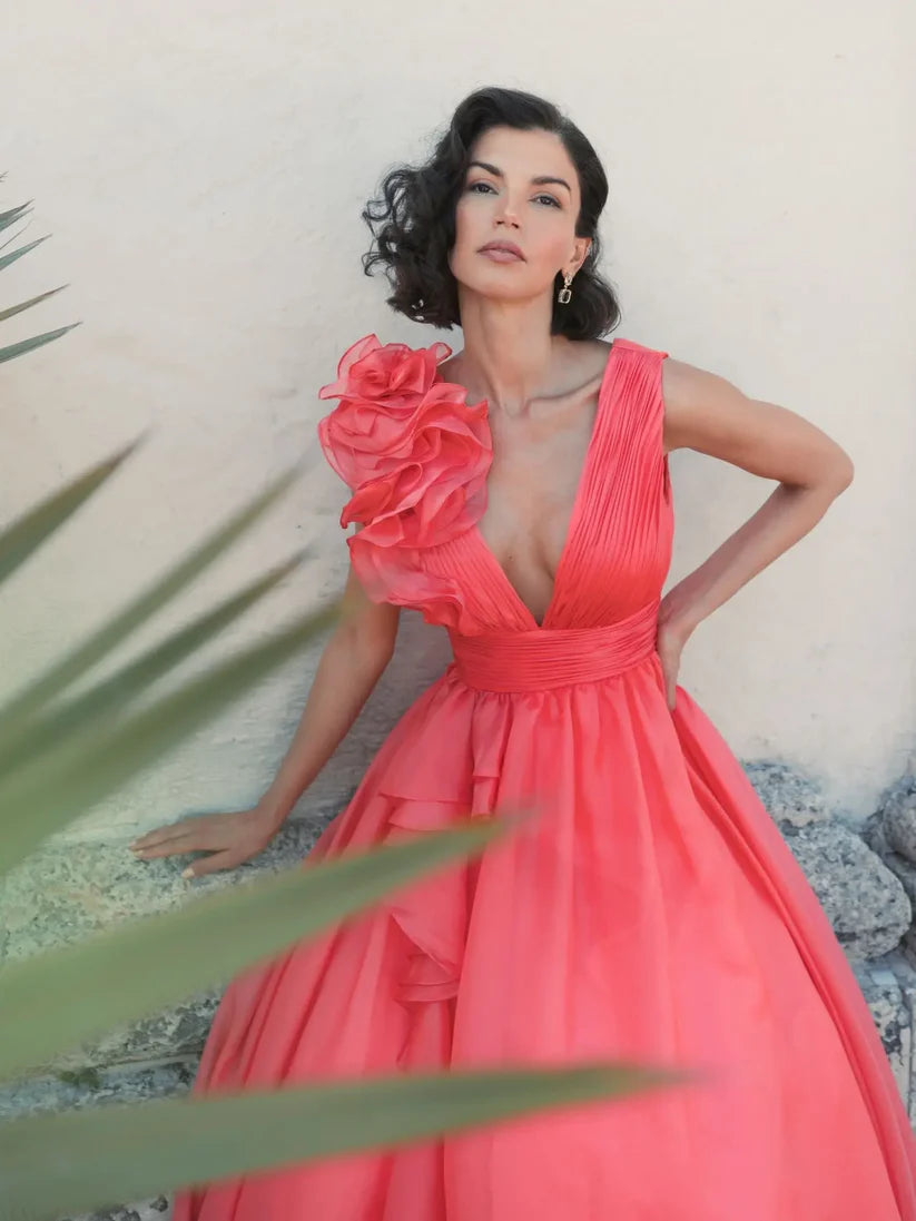 Model wearing Mac Duggal 48856 chiffon gown with V-neckline, ruffle shoulder detail, and flowing skirt.  Model wearing the color coral.  Front view.