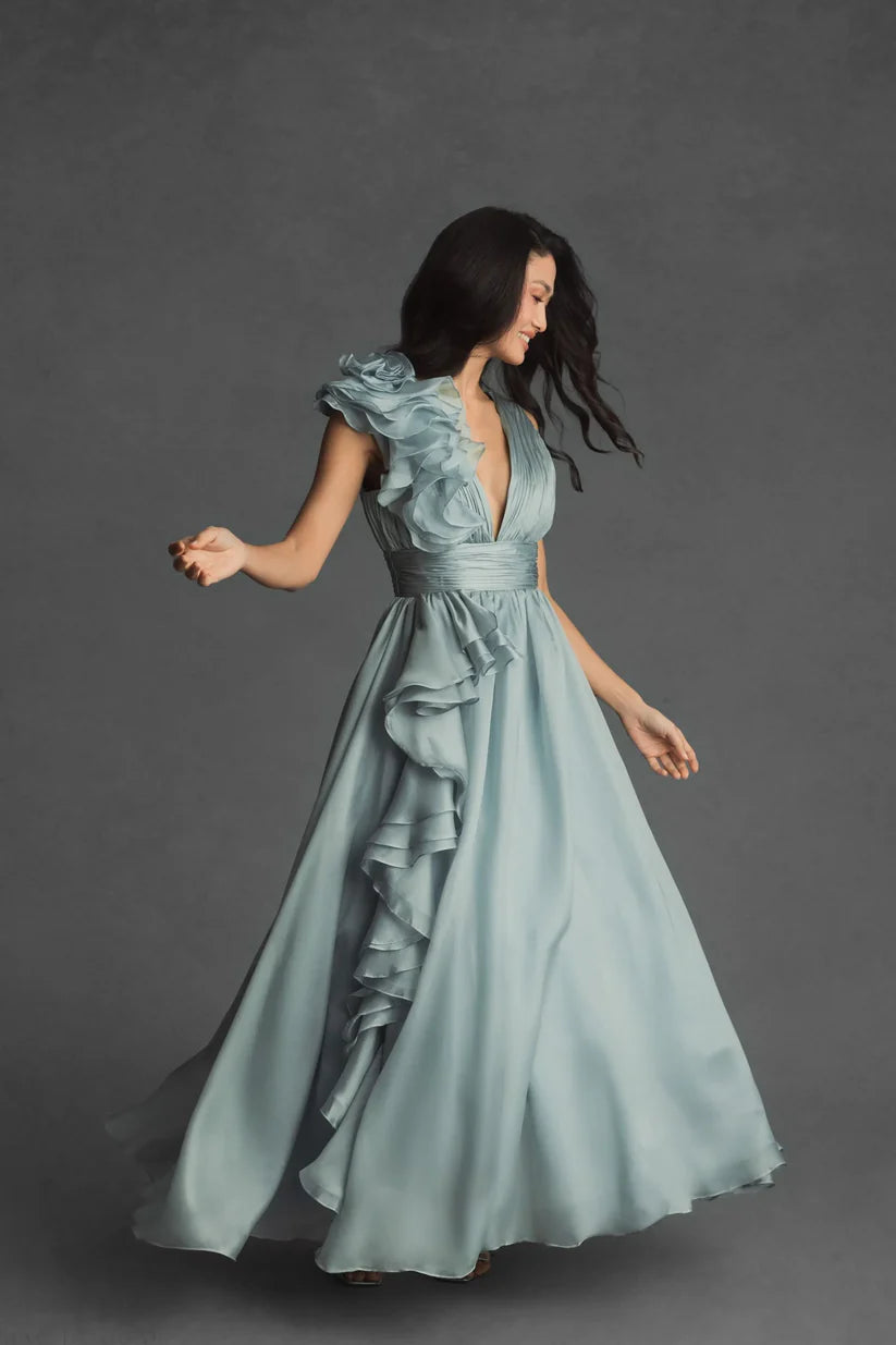 Model wearing Mac Duggal 48856 chiffon gown with V-neckline, ruffle shoulder detail, and flowing skirt.  Model wearing the color mint.  3/4 Front view.