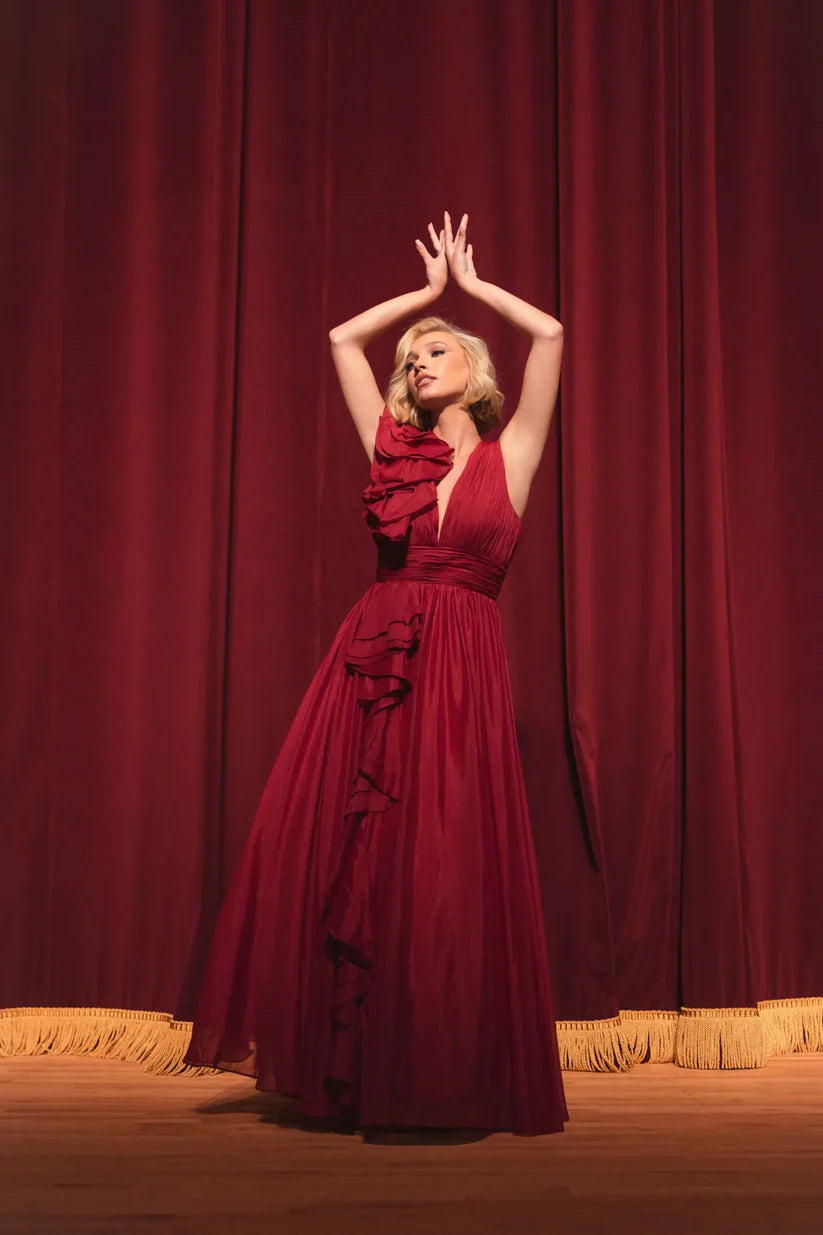 Model wearing Mac Duggal 48856 chiffon gown with V-neckline, ruffle shoulder detail, and flowing skirt.  Model wearing the color wine.  Front view.