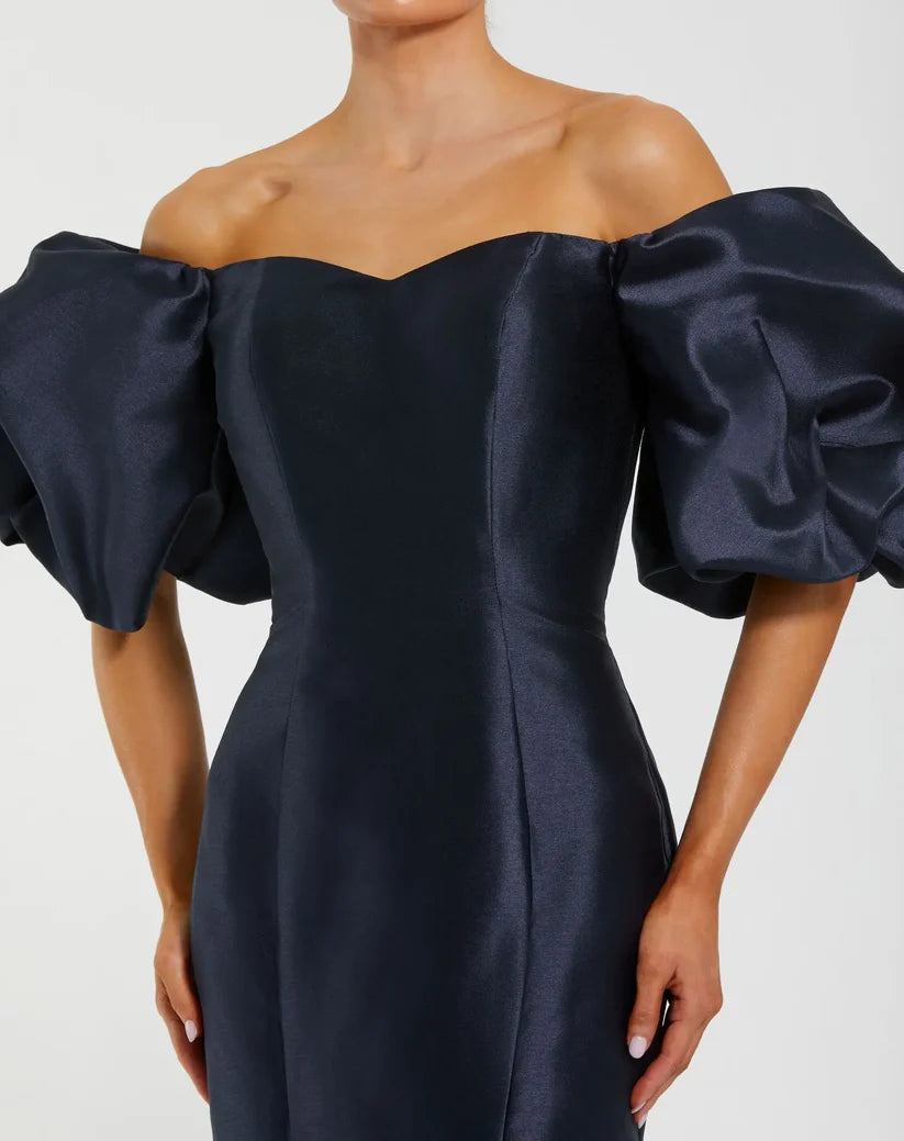 Model wearing Mac Duggal 50677 off-the-shoulder satin gown with puff sleeves, mermaid silhouette, and sweeping train.  Model is wearing the color midnight. Close Up view.