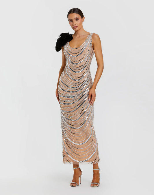 Model wearing Mac Duggal 94285 beaded gown with one-shoulder flower accent, cowl draped back, and ankle-length hem.